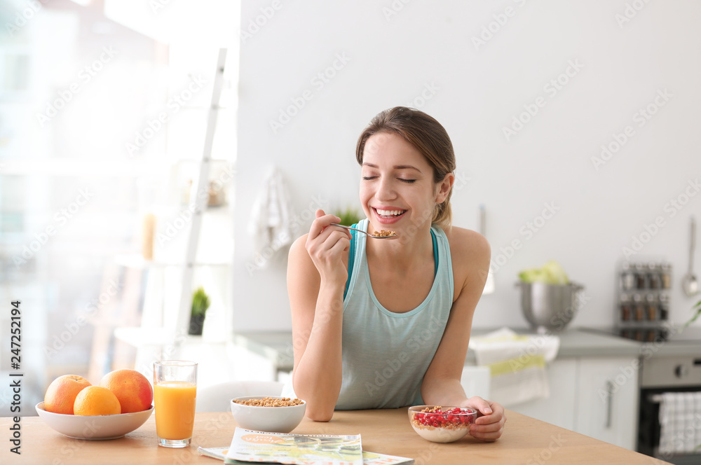 Young woman in fitness clothes having healthy breakfast at home