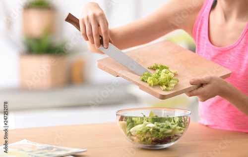 Young woman in fitness clothes preparing healthy breakfast at home, closeup