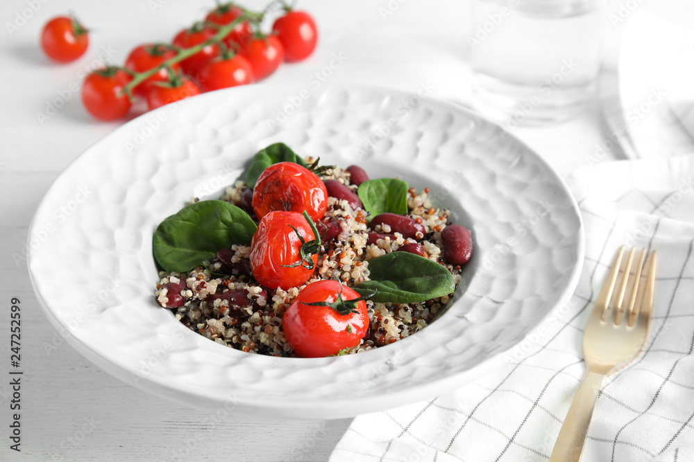 Plate with healthy quinoa salad and vegetables on table Plate with healthy quinoa salad and vegetables on table