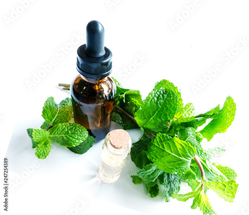 Peppermint essential oil in a bottle isolated on a white background