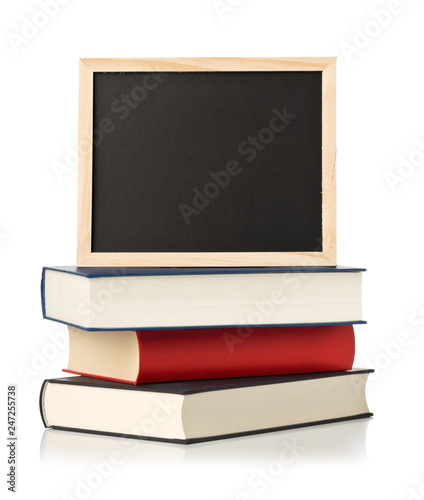 Photos Empty, blank, black chalkboard with stack of books over white