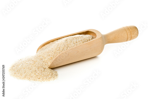 Heap of psyllium husk also called isabgol in wooden scoop over white background