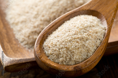 Heap of psyllium husk also called isabgol in wooden spoon and bowl on table photo