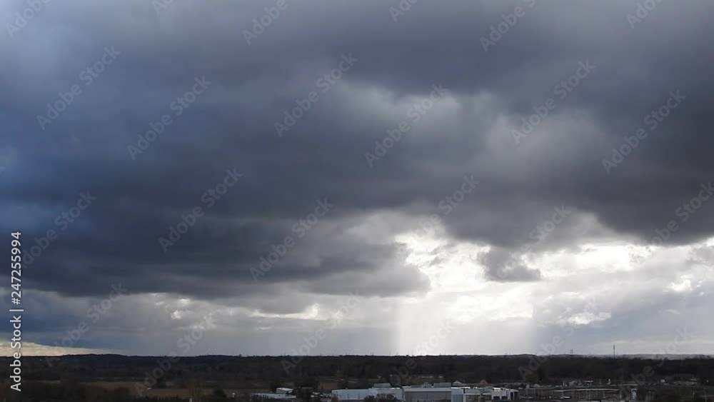 Dark Gray Grey Silver Clouds Timelapse With Sun Rays Breaking Through Clouds Onto Land And Hills And Mountains In Distance Dark Gray Grey Silver Clouds Timelapse With Sun Rays Breaking Through Clouds Onto Land And Hills And Mountains In Distance