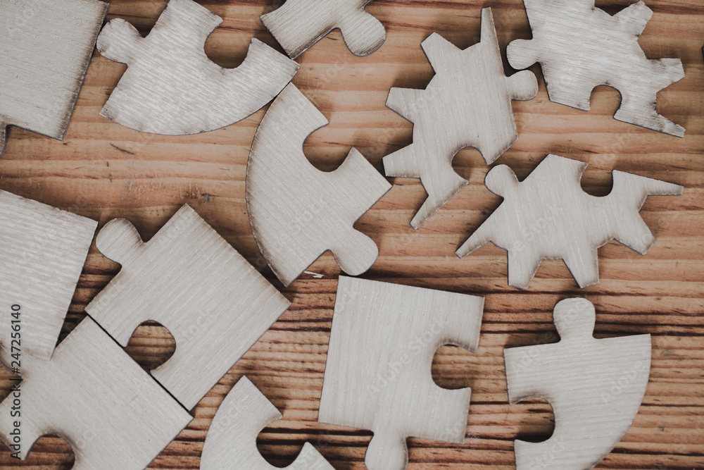 Wooden jigsaw puzzle is placed on an old wooden table. Wooden jigsaw puzzle is placed on an old wooden table.