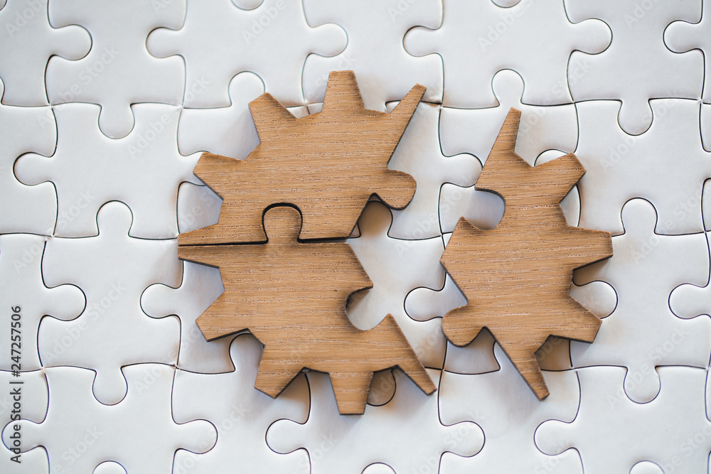 Three brown pieces of puzzle on a white jigsaw background, last piece of jigsaw puzzle to complete the mission, Business solutions, success and strategy concept Three brown pieces of puzzle on a white jigsaw background, last piece of jigsaw puzzle to complete the mission, Business solutions, success and strategy concept