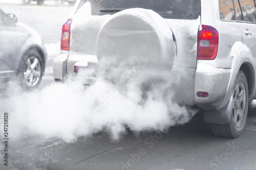 pollution from the exhaust of cars in the city in the winter. Smoke from cars on a cold winter day