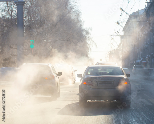 pollution from the exhaust of cars in the city in the winter. Smoke from cars on a cold winter day