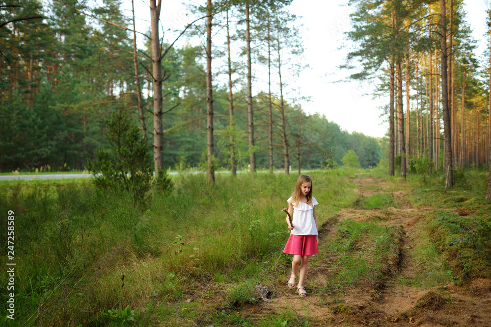 Cute young girl having fun during forest hike on beautiful summer day. Active family leisure. Cute young girl having fun during forest hike on beautiful summer day. Active family leisure.