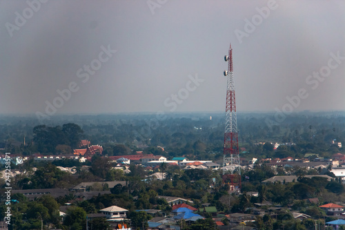 The communication tower with mobile telephone antenna in city
