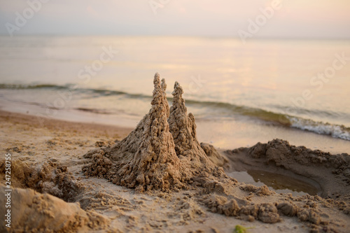 Sand castle built on the beach of Baltic sea on beautiful summer evening.