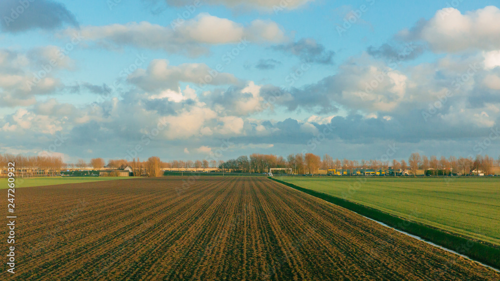 Fields under sky and clouds in the dutch countryside near Rotterdam, the Netherlands