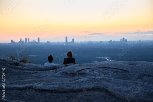 Two young women enjoying the twilight view of the distant Atlanta skyline.