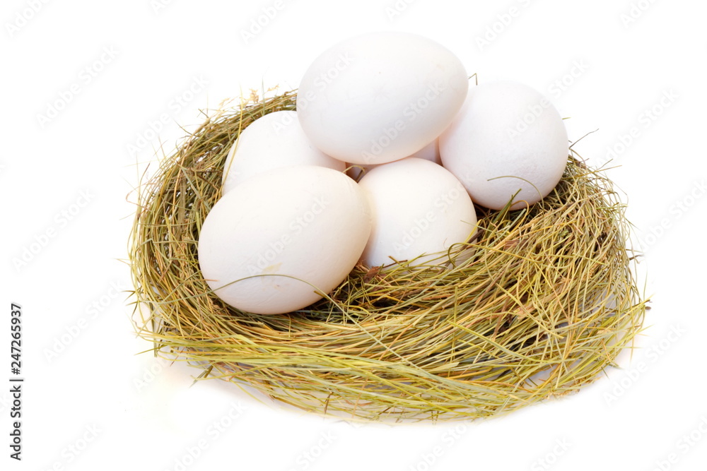 Heap white chicken eggs in a straw nest on white background. Isolated. Top view Heap white chicken eggs in a straw nest on white background. Isolated. Top view