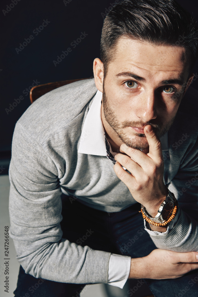Young thoughtful man holding finger on lips showing silence sign Young thoughtful man holding finger on lips showing silence sign