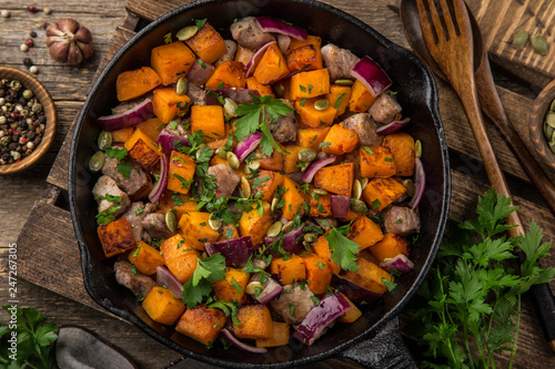 roasted pumpkin with meat on cast iron pan,  rustic backgroun