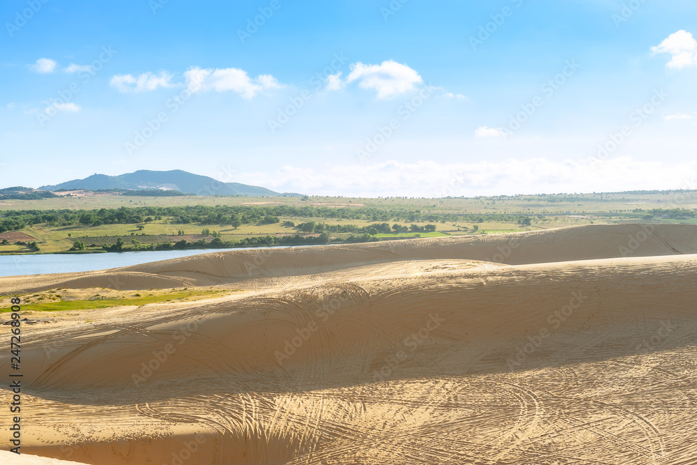 Landscape view of sand dunes with car trail at White Sand Dunes, Mui Ne, Vietnam.