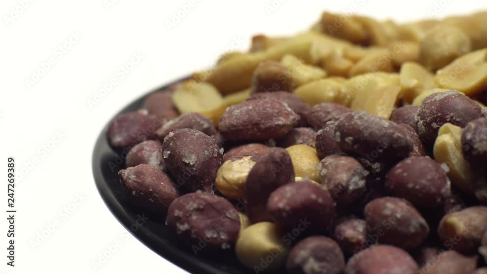 Peanuts. Mixed Peanuts in rotation. Snack closeup. Peanuts in a bowl. Selective focus. Isolated on white. Studio shot. Healthy food concept. Peanuts. Mixed Peanuts in rotation. Snack closeup. Peanuts in a bowl. Selective focus. Isolated on white. Studio shot. Healthy food concept.