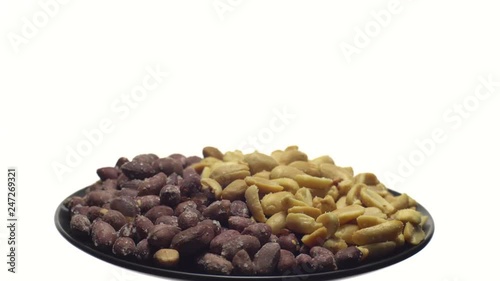 Peanuts. Mixed Peanuts in rotation. Snack closeup.   Peanuts in a bowl. Selective focus. Isolated on white. Studio shot. Healthy food concept.