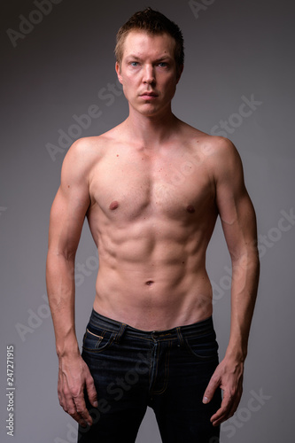 Studio shot of young handsome muscular shirtless man