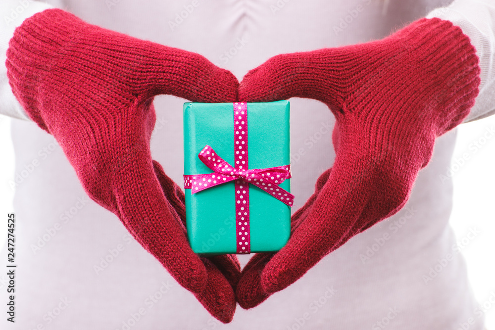 Hand of woman holding wrapped gift for Valentines Day or other celebration