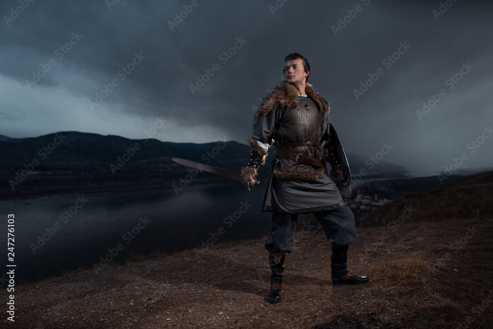 Medieval knight with sword and spear in ancient armour over Winter Landscapes
