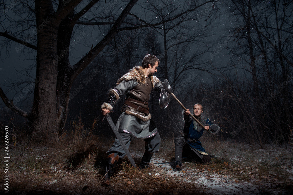 The battle between medieval knights in the style of Game of Thrones in winter forest landscapes. Spear against sword The battle between medieval knights in the style of Game of Thrones in winter forest landscapes. Spear against sword