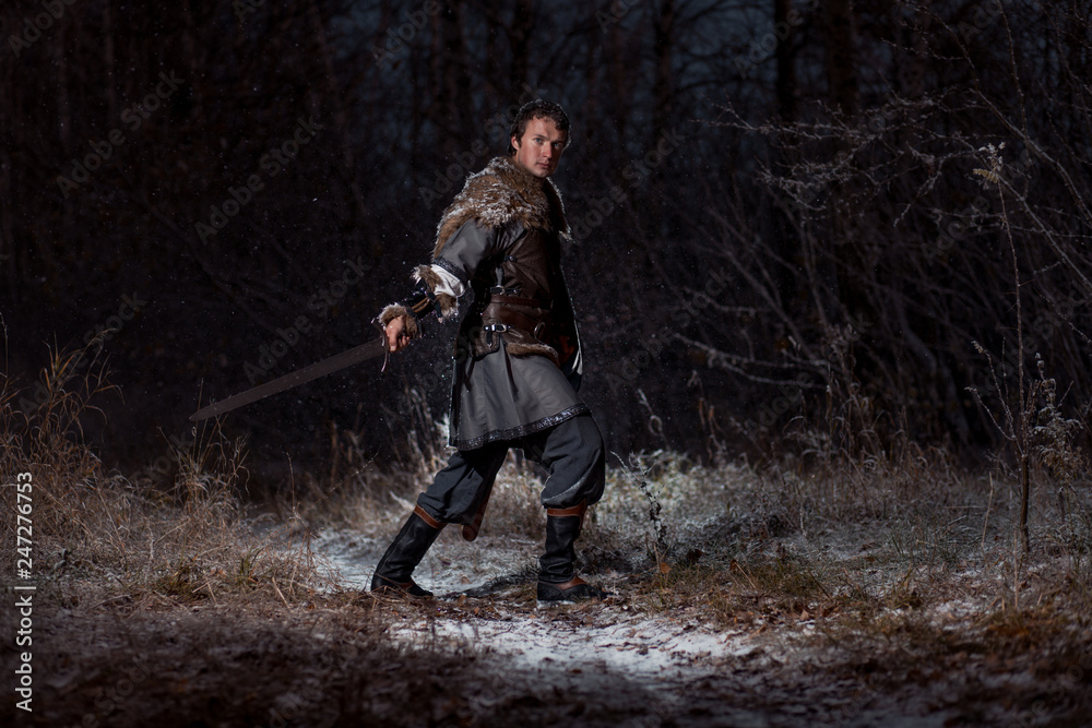 Medieval knight with sword in armor as style Game of Thrones in Winter Forest Landscapes