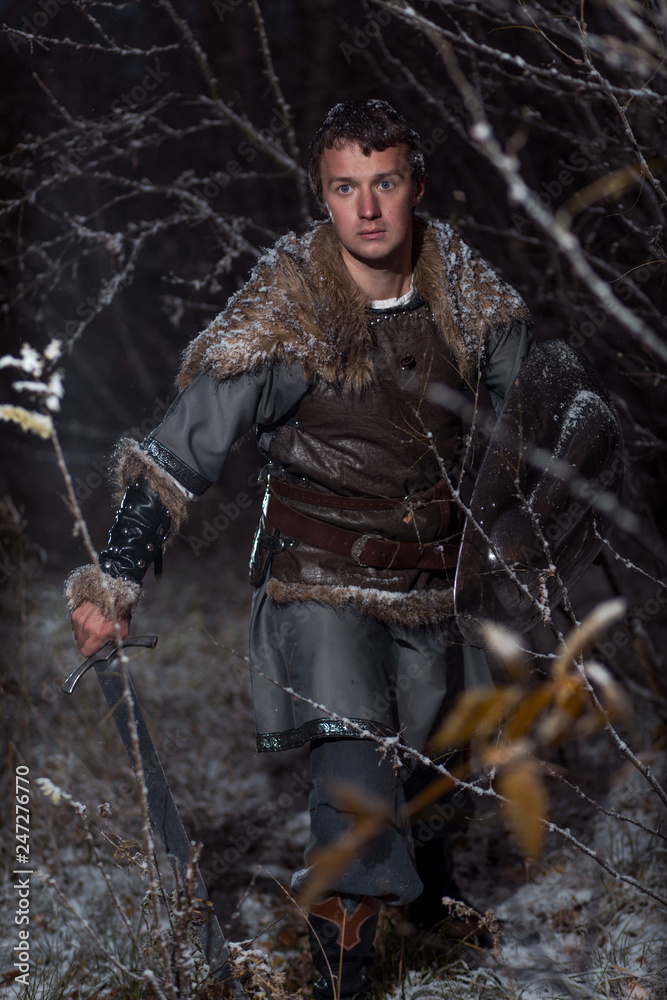 Medieval knight with sword in armor as style Game of Thrones in Winter Forest Landscapes