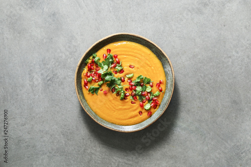 Fotografia Fresh pumpkin soup topped with parsley and pomegranate seeds