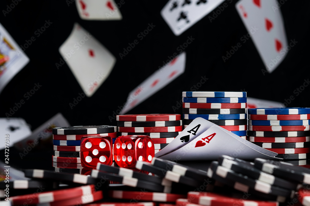 Obraz premium The concept of chips and cards for playing poker on the background of a flying cards