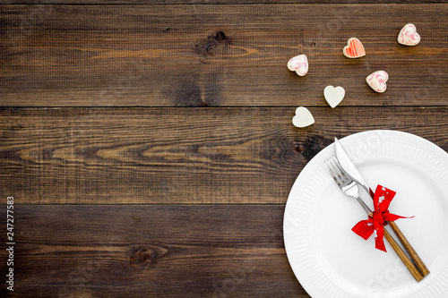 Dating in the restaurant on Valentine's day. Decorated dishes on dark wooden background top view copy space