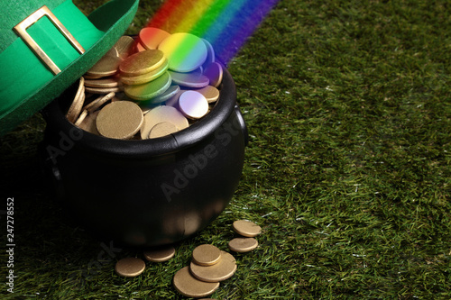 Black cauldron full of golden coins at theend of the rainbow photo