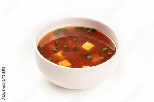 Fotografi A photo of a bowl of miso soup with tofu and scallions on a white background wit