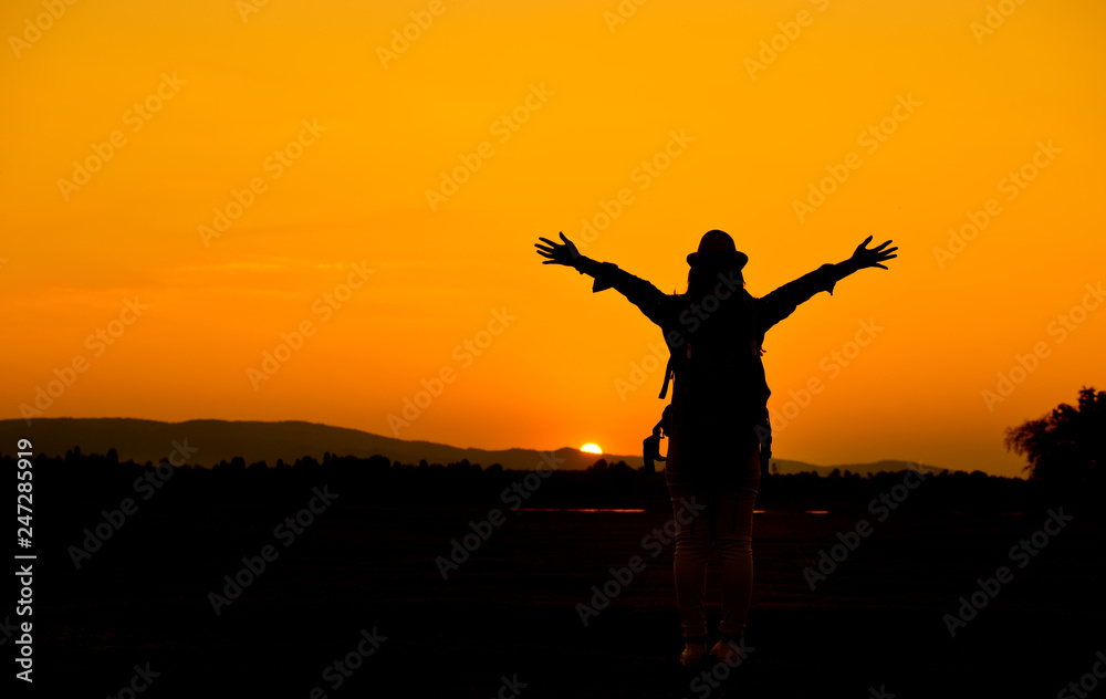 Silhouettes of happy female tourists at sunset
