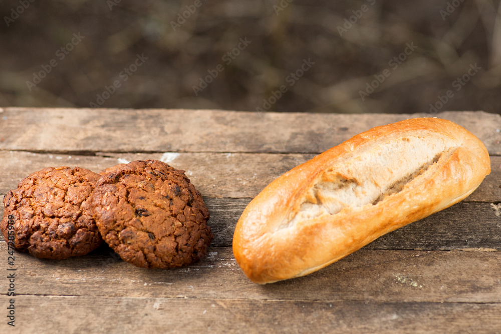 Assortment of fresh baked goods wooden background. baguette and cookies in the open space Assortment of fresh baked goods wooden background. baguette and cookies in the open space