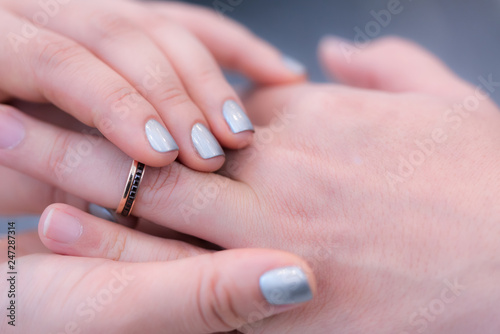 Wedding theme  Bride putting ring on groom hand  and they holding hands with a nice manicure neat. Close up hands of man and woman put wedding ring on hand.