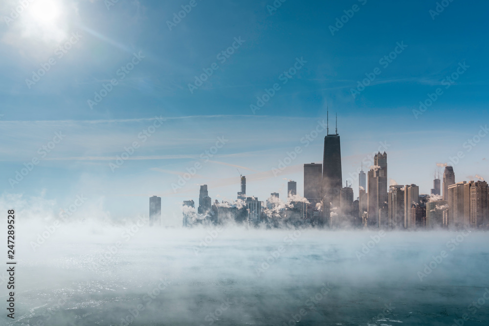 Sun above Chicago Downtown and Lake Michigan covers by fog from winter polar vortex