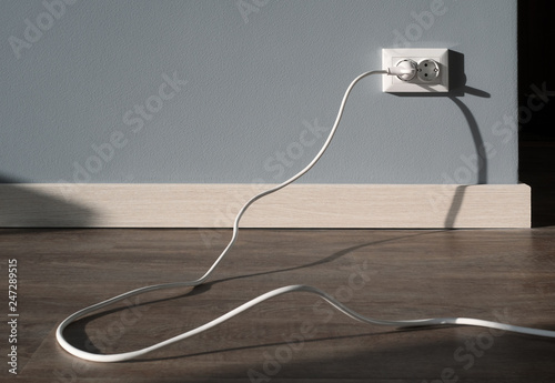 Power cord cable plugged into wall outlet