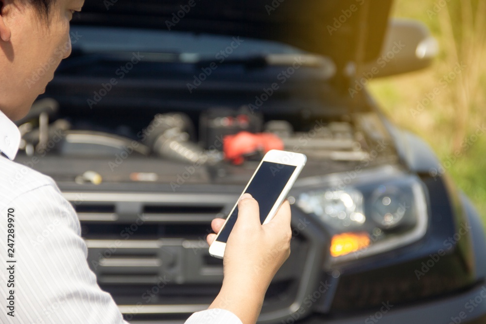 Using a mobile phone call a car mechanic because car was broken.
