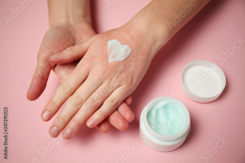 Female hands apply moisturizer to the skin. Irritation and allergies  frostbite.