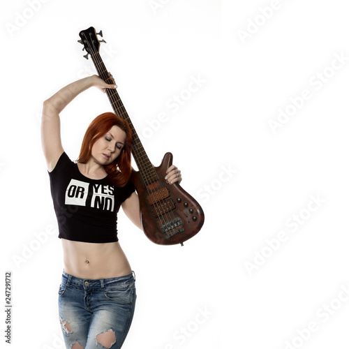 redhead woman holding electric guitar on a white background. rock girl playing on a guitar. free space for text