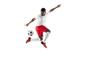 Professional african american football soccer player in motion isolated on white studio background. Fit jumping man in action, jump, movement at game.