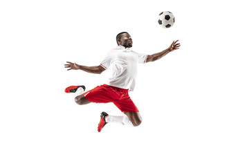 Professional african american football soccer player in motion isolated on white studio background. Fit jumping man in action, jump, movement at game.