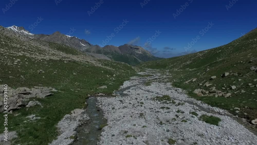 Flying over the mountain river. Beautiful mountains of Trans-Ili Alatau. Kazakhstan, Almaty. In summer. Flying over the mountain river. Beautiful mountains of Trans-Ili Alatau. Kazakhstan, Almaty. In summer.