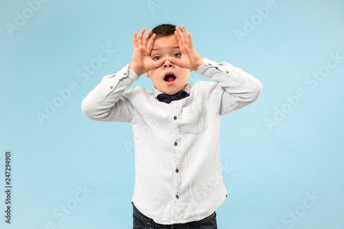 I'm afraid. Fright. Portrait of the scared boy. Teenager standing isolated on trendy blue studio background. male half-length portrait. Human emotions, facial expression concept