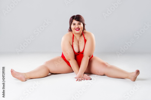 Plus size fashion model in red lingerie  fat woman in underwear on gray studio background  overweight female body