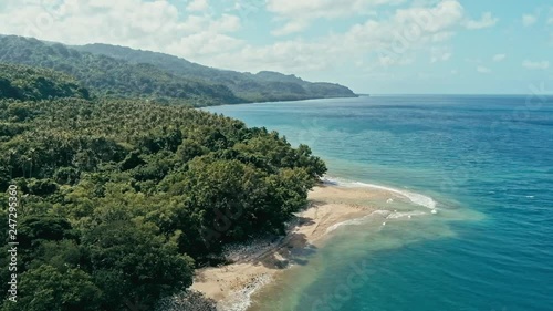 aerial drone footage of a remote south pacific island with sandy beach shore and beautiful ocean sea seascape and lush tropical rainforest jungle with a reef and river photo