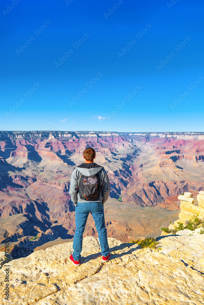 Young guy on the edge of a cliff on the Grand Canyon.