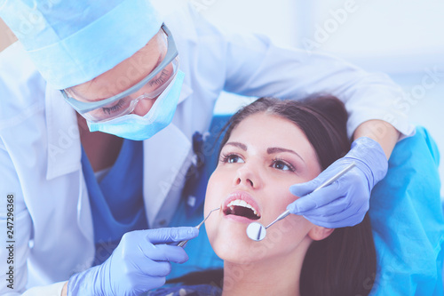Woman dentist working at her patients teeth . Woman dentist